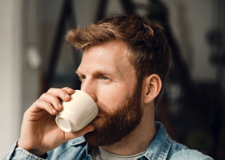 bărbat care bea o ceașcă de cafea